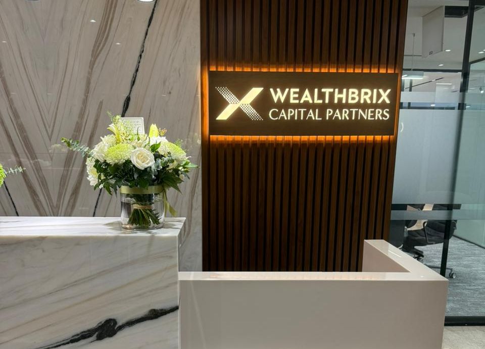 Wealthbrix Capital Partners reception with marble desk and backlit timber feature wall